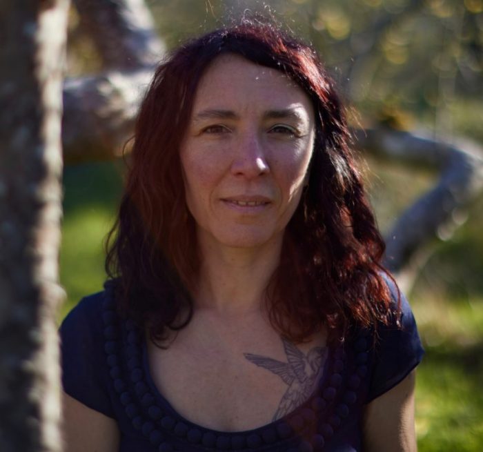 Adi Howarth under a tree in dappled light.